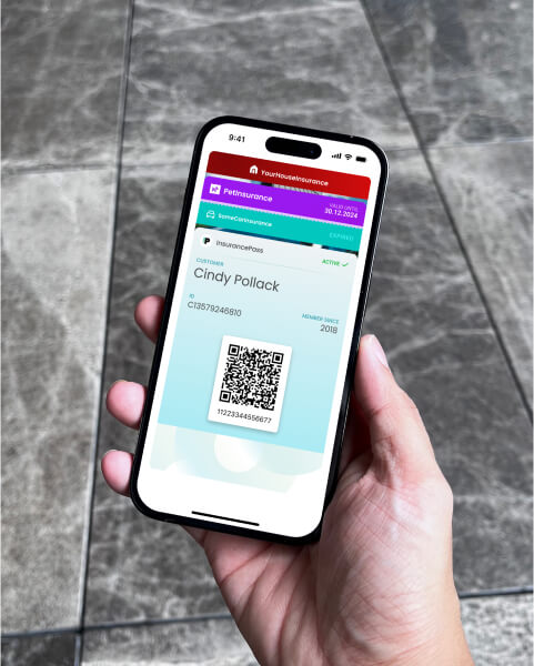 A hand holding an iPhone with iPhone Wallet cards visible